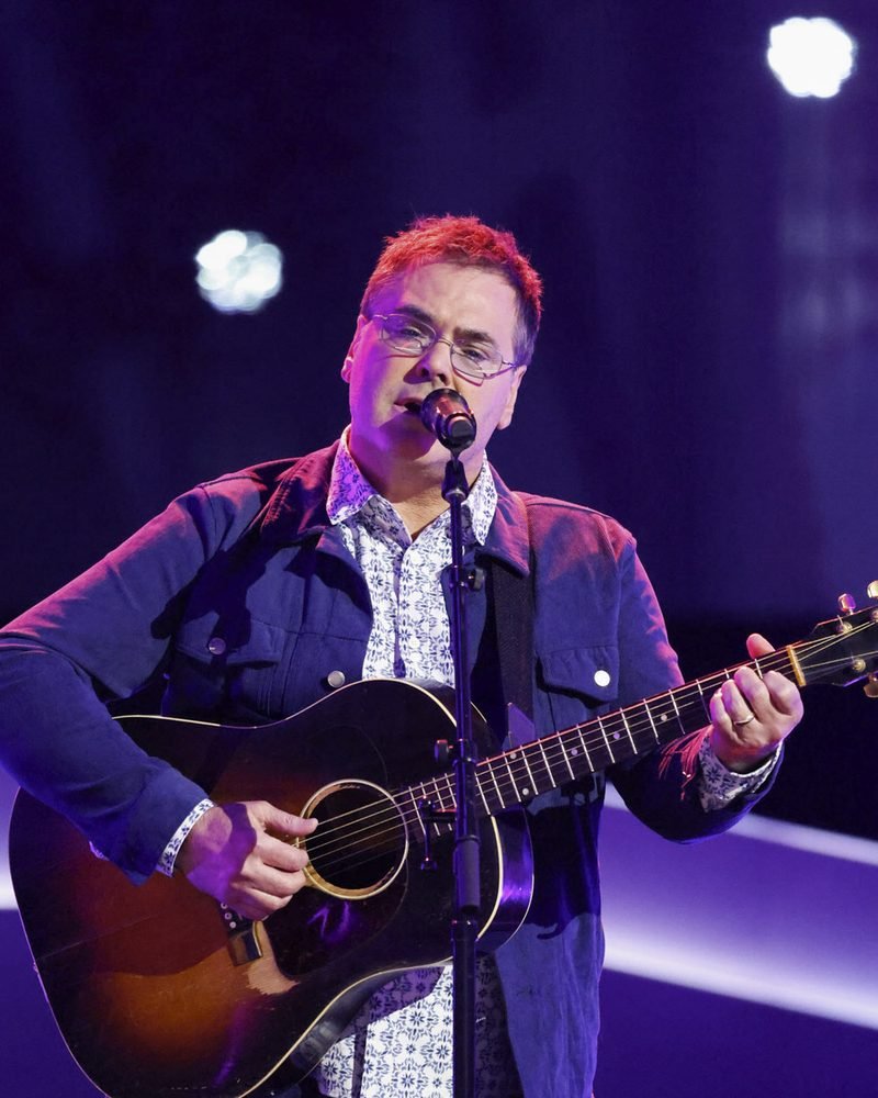 Kyle Davis singing with an acoustic guitar during his four-chair turn blind audition on The Voice Season 30