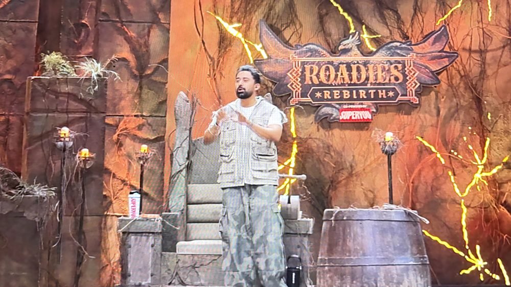 Rannvijay Singha hosting Roadies Rebirth in front of the show logo